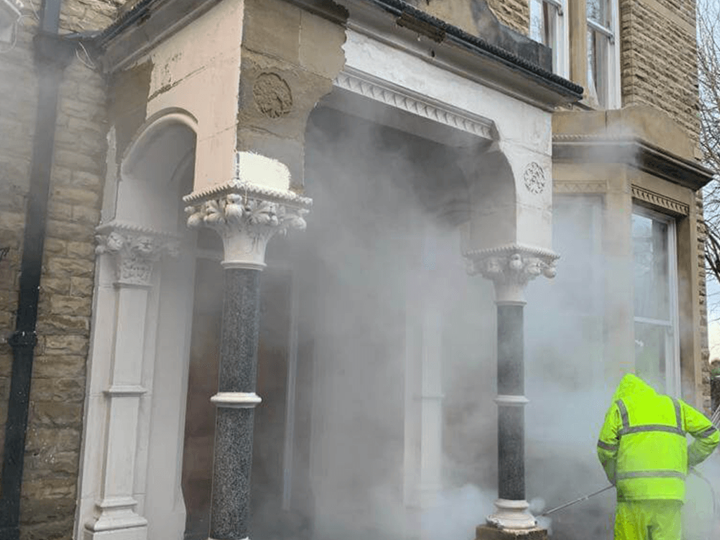 Team sandblasting porch pillar.