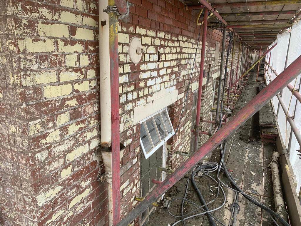 Before image of paint stripped outer wall.