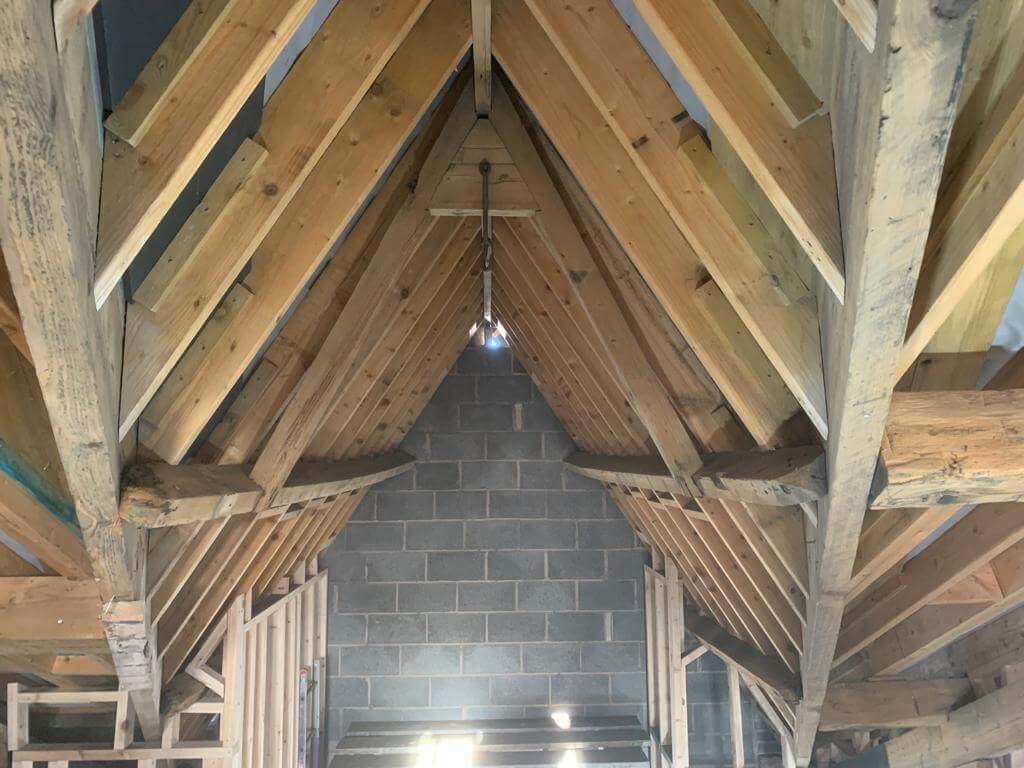After image showing interior loft wooden beams cleaned and vibrant.