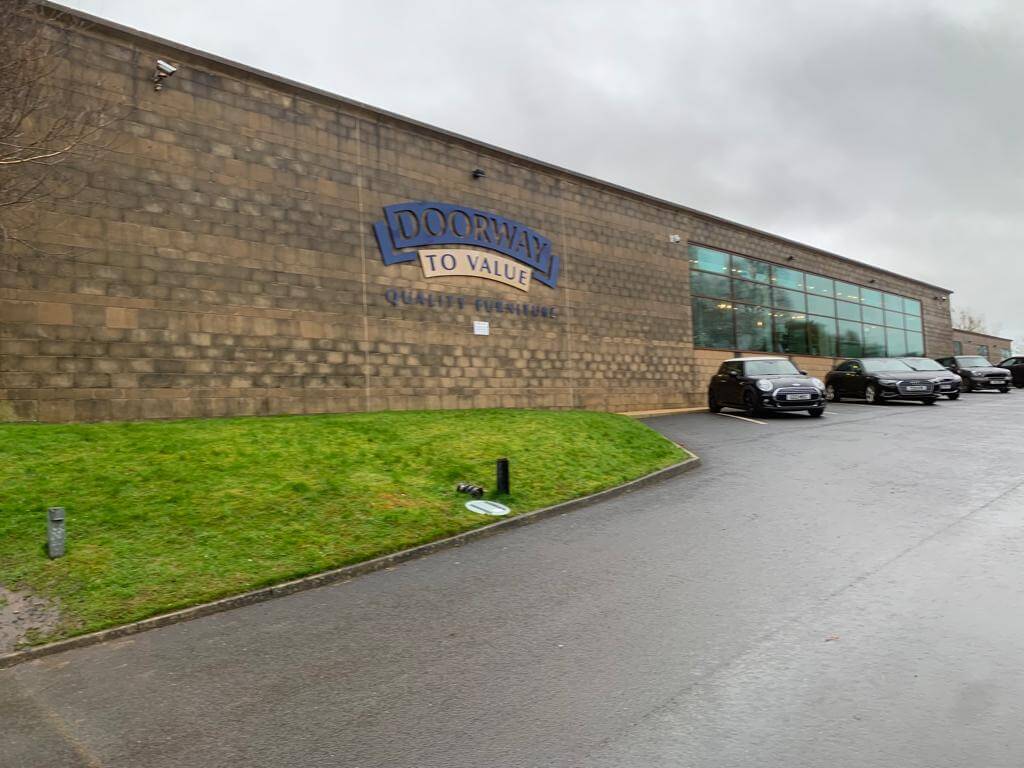 Outside before image of large commercial building with stained brickwork throughout.