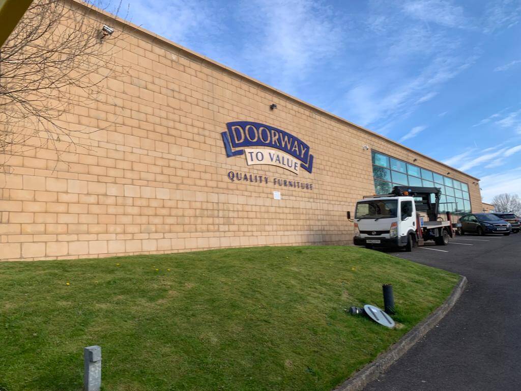 Outside after image of large commercial building showing clean limestone brickwork after soda blasting job completed.