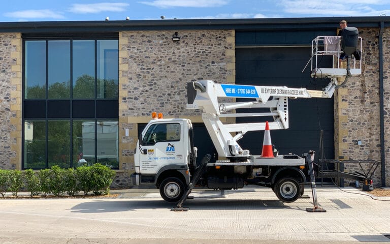 JJL branded cherry picker parked next to roofing project.