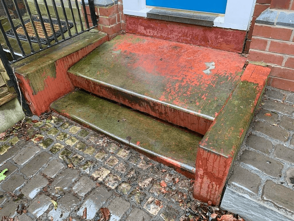 Before image of doorstep with flaking red paint and covered in moss.