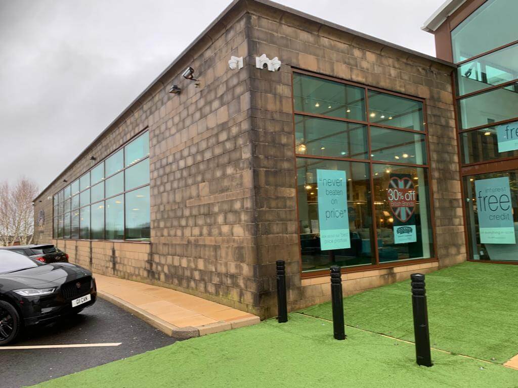 Before image of commercial property outer wall stained with moss growing on bottom.